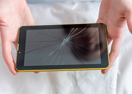 Hands holding a broken tablet